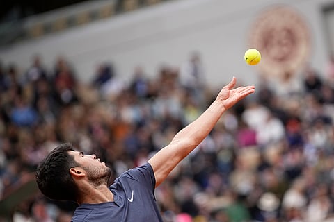 Carlos Alcaraz serves against Felix Auger-Aliassime